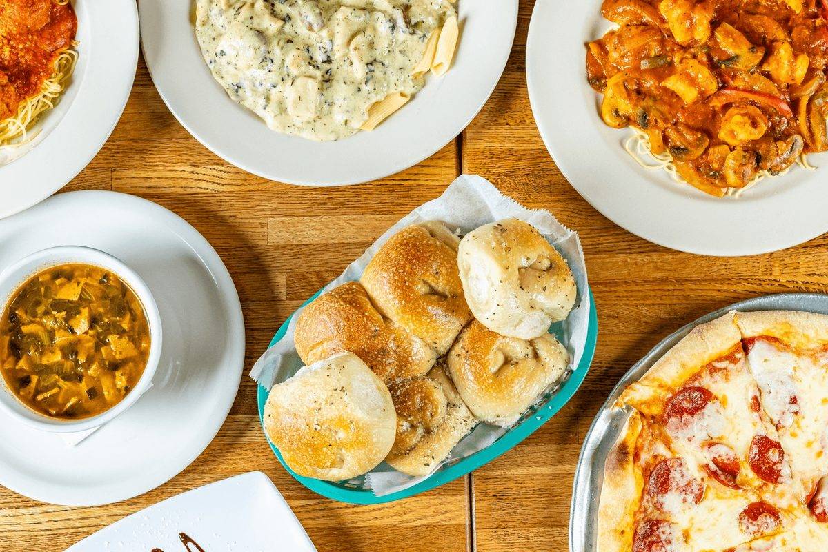 Spaghetti, baked ziti, shrimp pasta, garlic rolls, soup and pepperoni pizza on a table at Tuscany Italian Restaurant in Port Arthur